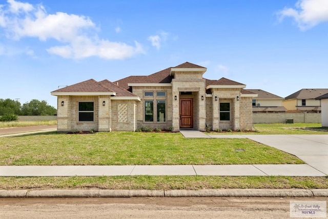 5112 Blackhawk Ave, Rio Grande City, TX 78582 - prairie-style home with a shingled roof, brick siding, and a front yard