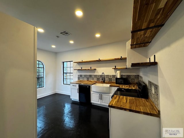 kitchen with butcher block counters, a sink, visible vents, black appliances, and open shelves