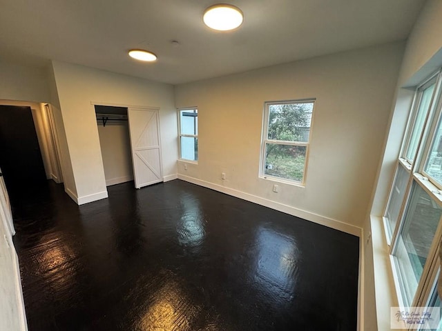 unfurnished bedroom with a closet and baseboards