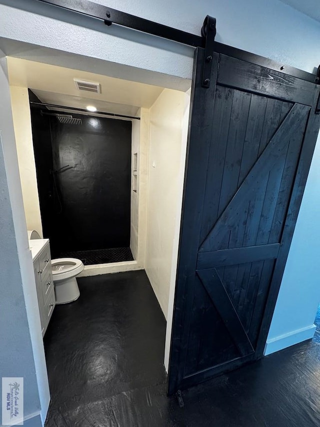 bathroom featuring a stall shower, baseboards, visible vents, toilet, and vanity