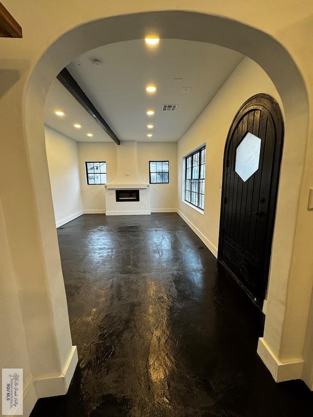 foyer entrance with arched walkways, recessed lighting, visible vents, and baseboards