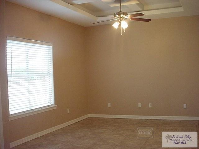 unfurnished room featuring ceiling fan and a raised ceiling