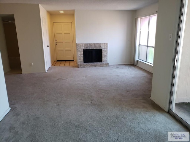 unfurnished living room with a fireplace and light colored carpet