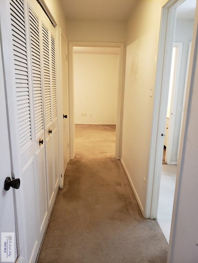 hall with light colored carpet