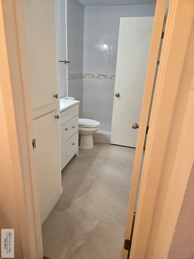 bathroom with vanity, toilet, and a shower