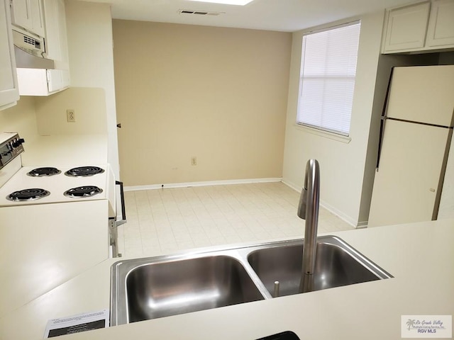 kitchen with white appliances, white cabinetry, and sink