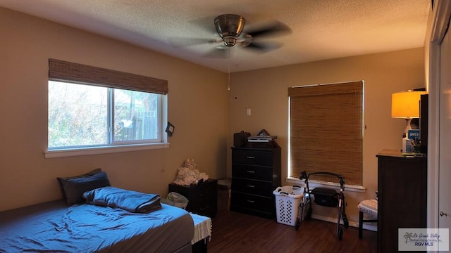 bedroom featuring ceiling fan, dark wood-style floors, and a textured ceiling