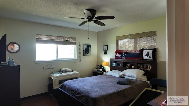 bedroom featuring dark wood-type flooring, a ceiling fan, and a textured ceiling