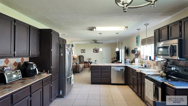 kitchen with backsplash, appliances with stainless steel finishes, a peninsula, a toaster, and light tile patterned floors