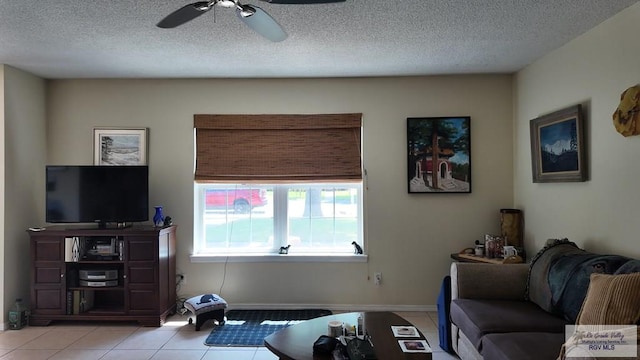 living room featuring light tile patterned floors, baseboards, a textured ceiling, and ceiling fan