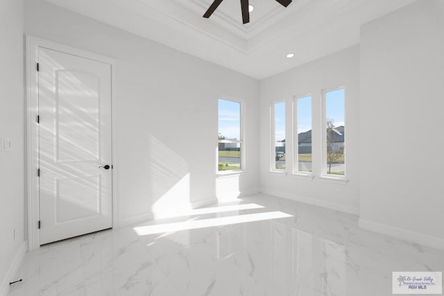 empty room featuring a tray ceiling, ceiling fan, and ornamental molding