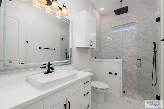 bathroom with vanity, a shower with shower door, and toilet