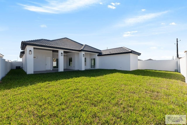 rear view of house featuring a lawn