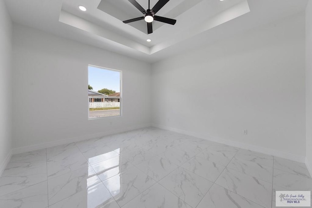 unfurnished room with a tray ceiling and ceiling fan