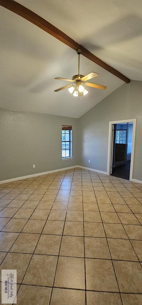 tiled empty room featuring lofted ceiling with beams and ceiling fan