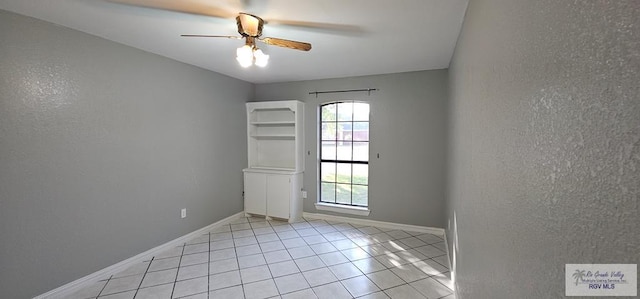 tiled spare room featuring ceiling fan