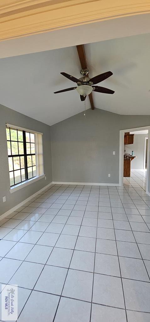 tiled spare room featuring vaulted ceiling with beams and ceiling fan