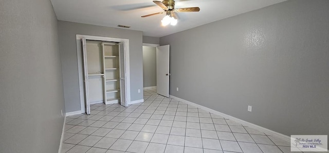 unfurnished bedroom featuring light tile patterned flooring, ceiling fan, and a closet