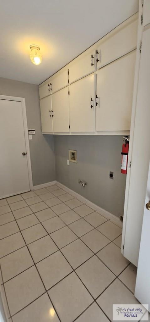 laundry room with gas dryer hookup, light tile patterned floors, cabinets, washer hookup, and hookup for an electric dryer