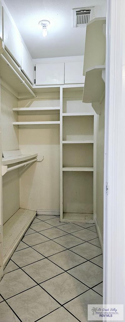 spacious closet with light tile patterned floors