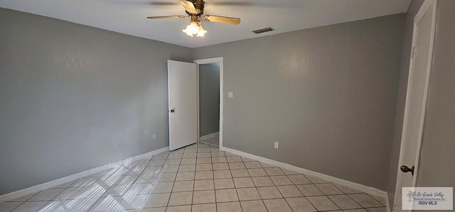 tiled spare room with ceiling fan