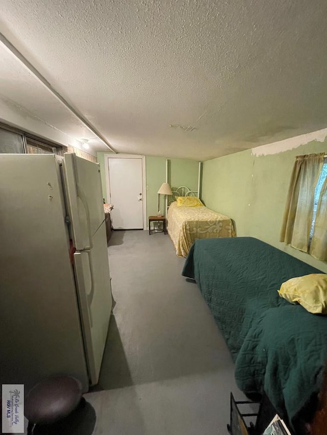 1105 Colt St, La Feria, TX 78559 - bedroom with freestanding refrigerator and a textured ceiling