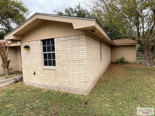 1105 Colt St, La Feria, TX 78559 - view of property exterior with brick siding and a lawn