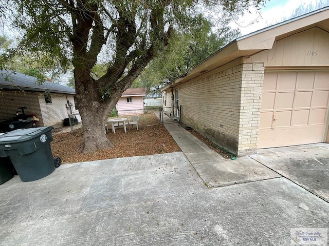 1105 Colt St, La Feria, TX 78559 - view of side of home with brick siding and driveway