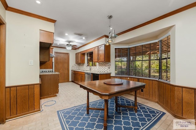 dining room featuring wooden walls, ceiling fan, and crown molding