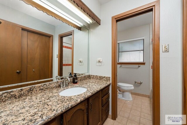 bathroom featuring tile patterned flooring, vanity, and toilet