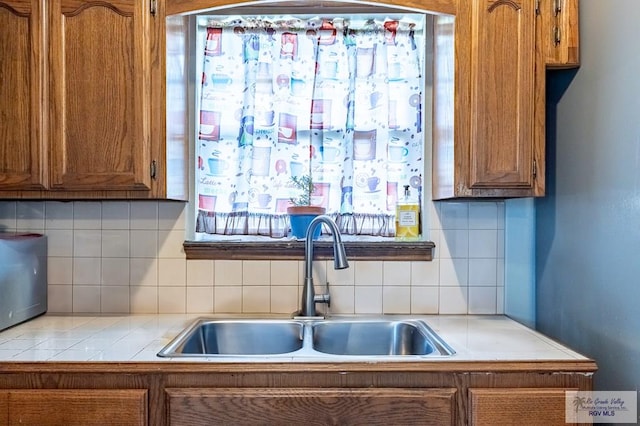 3053 Fairfield Dr, Brownsville, TX 78526 - kitchen featuring brown cabinets and decorative backsplash