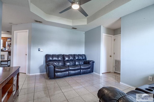 3053 Fairfield Dr, Brownsville, TX 78526 - living area featuring light tile patterned floors, a ceiling fan, and a tray ceiling