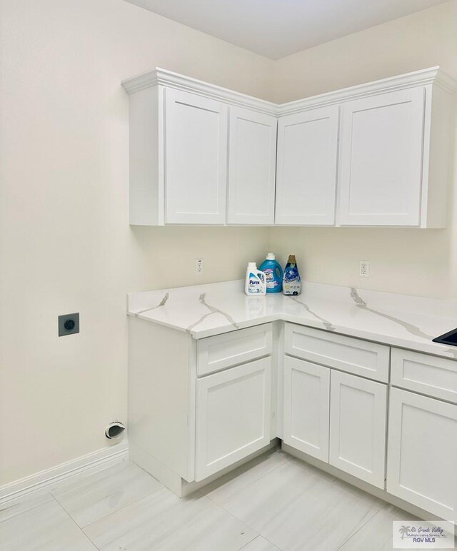 clothes washing area with electric dryer hookup and baseboards