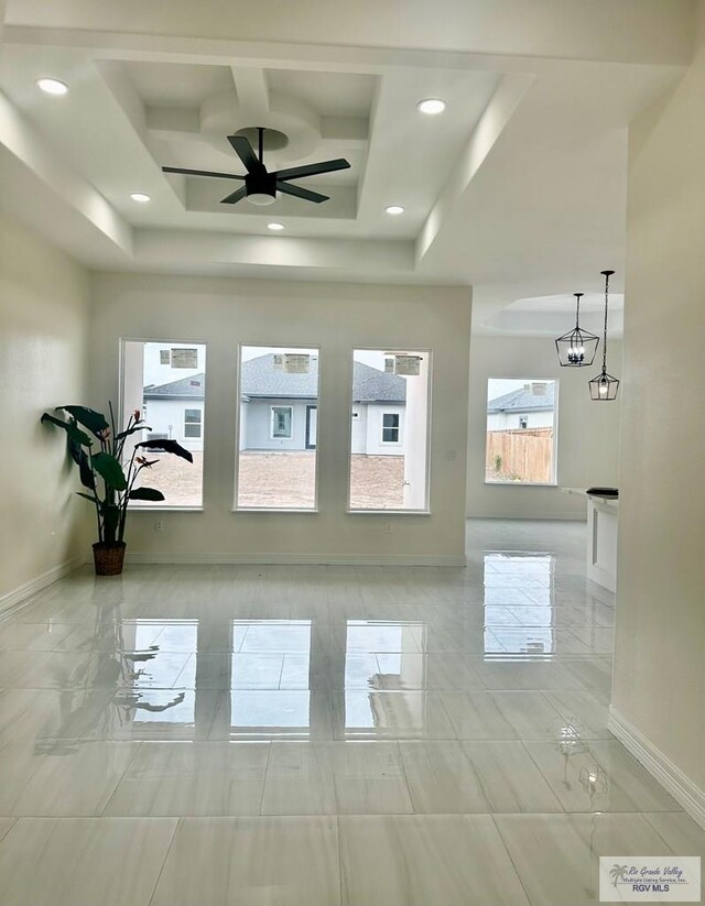 interior space with baseboards, coffered ceiling, a raised ceiling, ceiling fan with notable chandelier, and recessed lighting