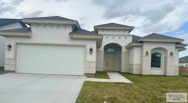 view of front of property featuring driveway, stucco siding, an attached garage, and a front yard