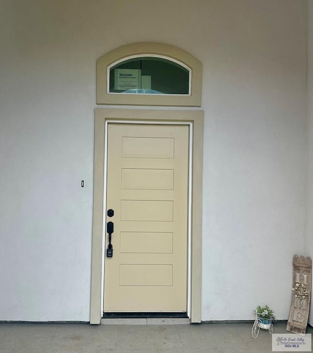 entrance to property featuring stucco siding