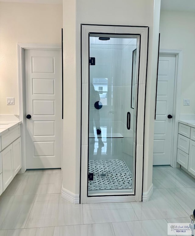 full bath with a shower stall and vanity