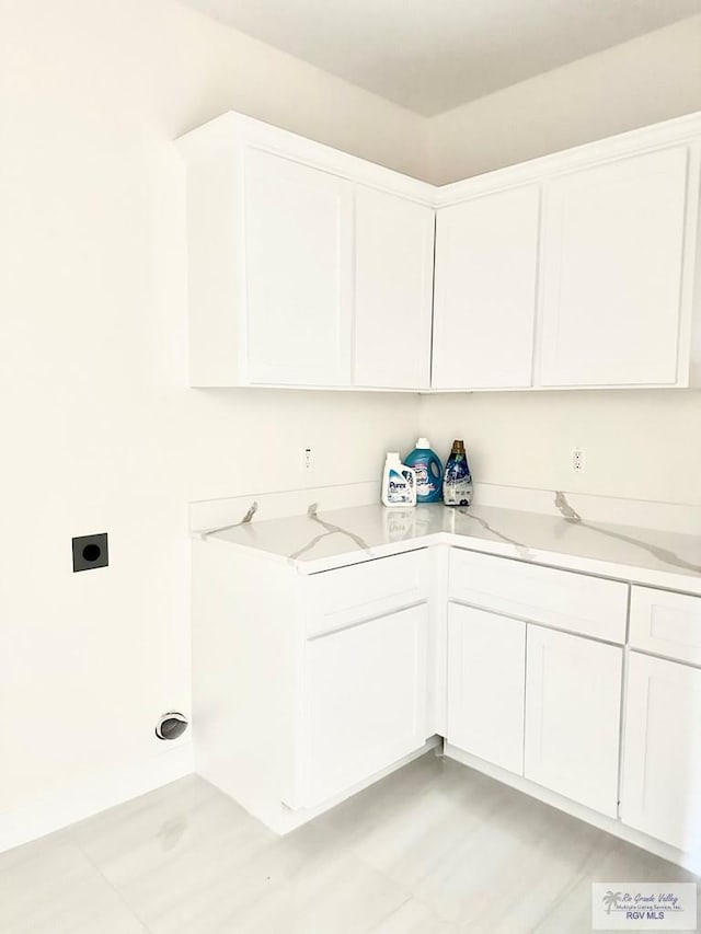 clothes washing area featuring hookup for an electric dryer and cabinet space