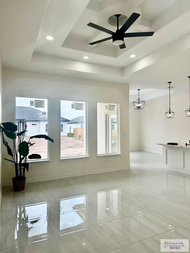 living room with baseboards, a raised ceiling, a ceiling fan, and recessed lighting