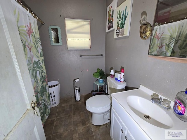 bathroom featuring tile patterned flooring, vanity, and toilet