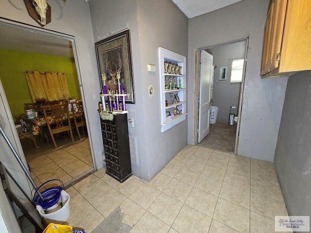 hall with light tile patterned floors