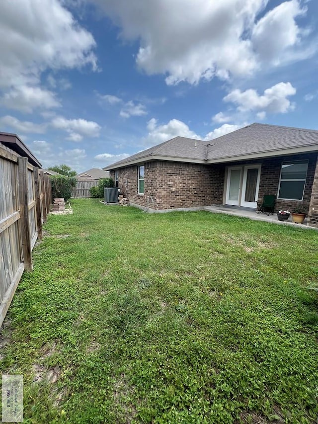 view of yard with a patio, central AC unit, and a fenced backyard