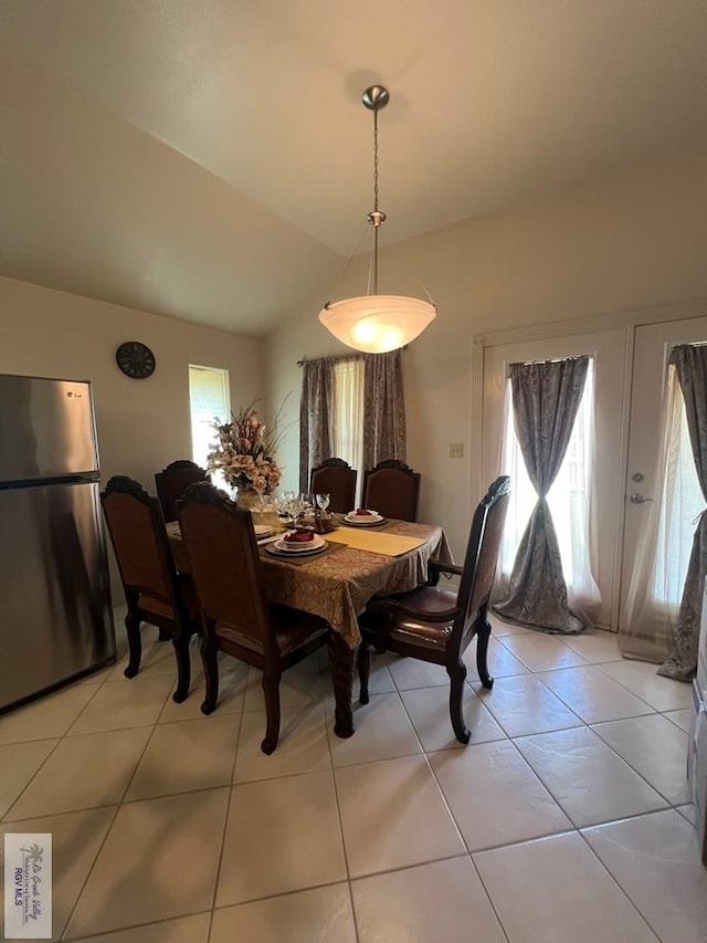 dining space featuring light tile patterned floors and lofted ceiling