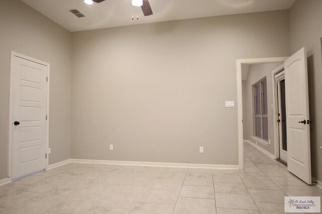 empty room with ceiling fan, visible vents, baseboards, and light tile patterned flooring