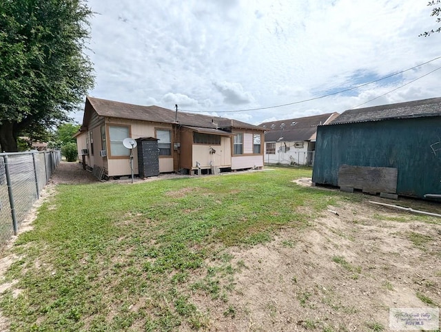 back of property featuring a yard and fence