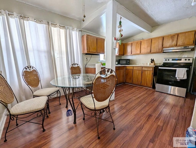 kitchen featuring lofted ceiling with beams, black microwave, under cabinet range hood, stainless steel range with electric cooktop, and light countertops