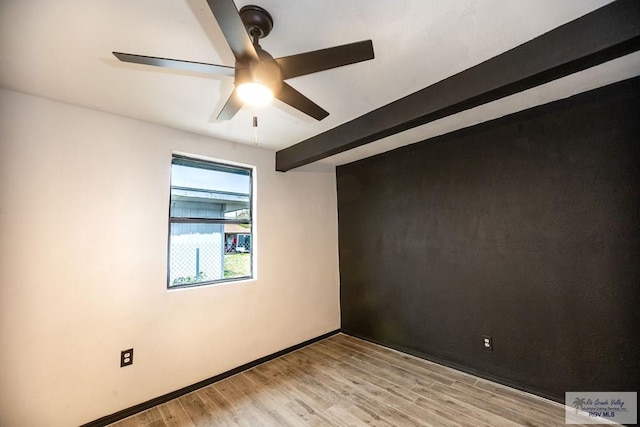 spare room with ceiling fan, light wood finished floors, beam ceiling, and baseboards