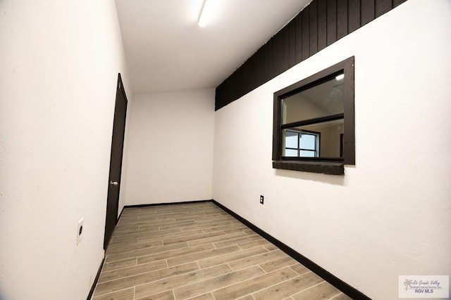 spare room featuring wood finish floors and baseboards