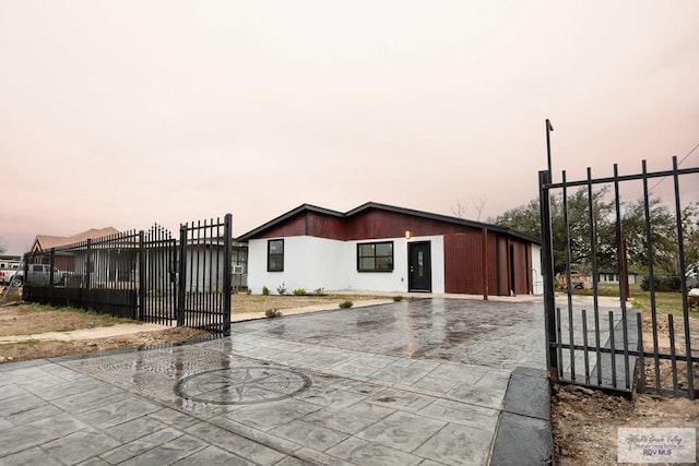 view of front of home with a gate, fence, and driveway