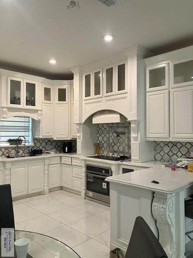 kitchen featuring white cabinets, stainless steel oven, backsplash, and gas cooktop